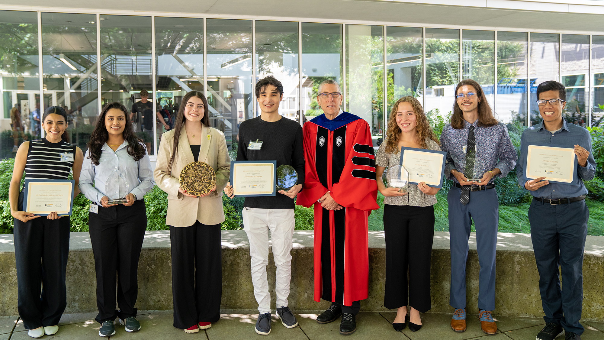 A group shot of award recipients with CBS dean in regalia