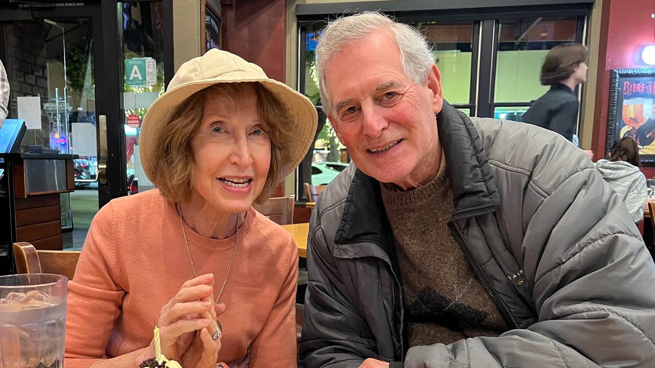 Mark and Marsha leaning into one another in a restaurant 