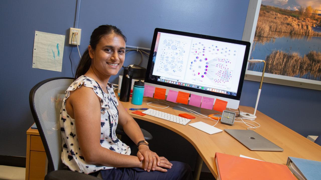 Priya Shah at her desk with a computer