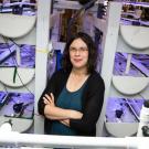 Kristin Aquilino stands next to beds holding juvenile white abalone