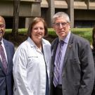 A group of leaders and the donor standing outside in sunlight with grass in the background.