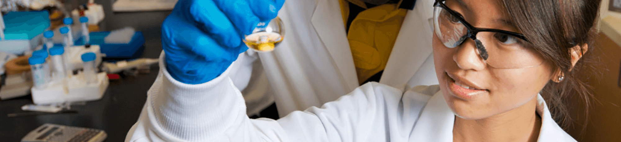 Student researchers examine a beaker in the lab